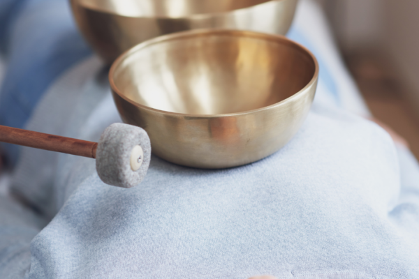 Klangmassage in tiefer Entspannung in Verl Klangmassage mit goldenen Klangschalen auf Brust und Becken einer liegenden Frau